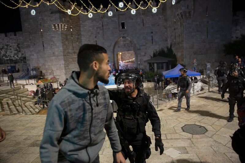 An Israeli policeman tells a Palestinian man to leave the Damascus Gate. The Palestinian Red Crescent said more than 160 people were injured in clashes with police on Friday night. AP Photo