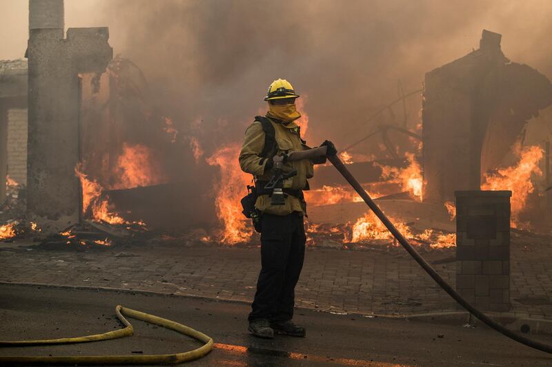A firefighter works as a home burns during the 'Thomas Fire' which began overnight in Ventura, California. John Cetrino / EPA