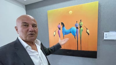 Jordanian art collector Hasan Wahbeh discusses a surreliast work by Kuwaiti painter Khalid Al Shari. Khaled Yacoub Oweis / The National