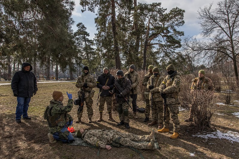 Members of the Territorial Defence Forces learn how to give first aid during the training session. EPA