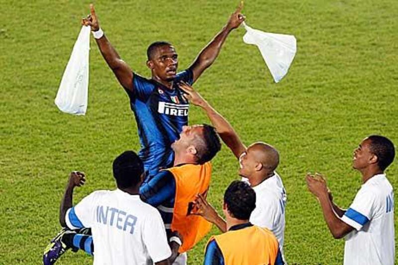 Samuel Eto'o of Inter Milan celebrates scoring the team's second goal against TP Mazembe with a bizarre display involving plastic bags. Ahmed Jadallah / Reuters