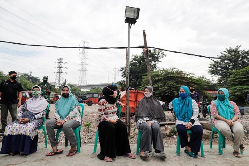 Residents wait for their turn during an aid package distribution by the Indonesian Air Force at a slum area in Jakarta, Indonesia. EPA