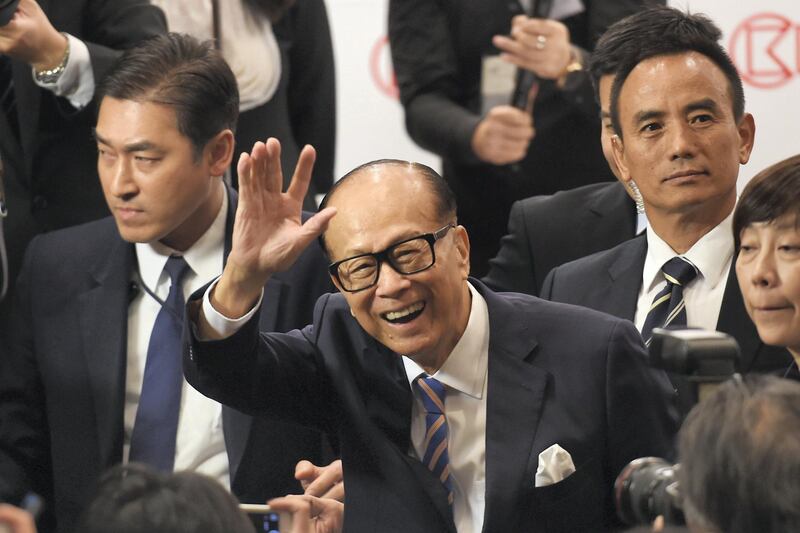 Hong Kong's richest man Li Ka-shing (C), 89, waves as he leaves a press conference in Hong Kong on March 16, 2018.
Hong Kong's richest man Li Ka-shing announced on March 16 he was stepping down as chairman of his flagship company CK Hutchison, marking the end of an era for one of the world's most storied tycoons. Li, who is turning 90 in July this year, has finally concluded mounting speculation about his retirement as he is expected to hand over the reins to his eldest son Victor. / AFP PHOTO / Anthony WALLACE