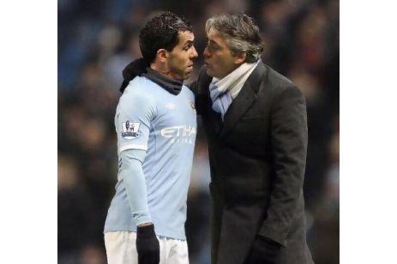 The relationship between Tevez, left, and his manager Roberto Mancini is said to be strained. Jon Super / AP Photo