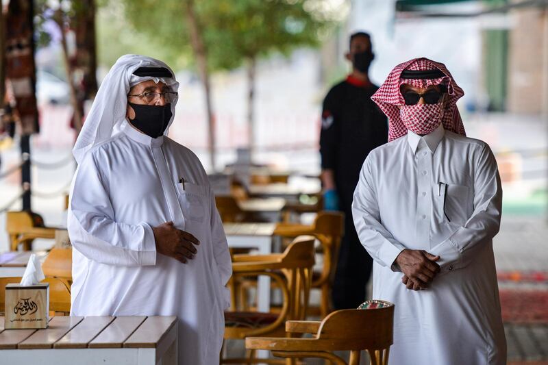 Mask-clad clients wait for their table to be sanitised upon arriving at a cafe in Saudi Arabia's capital Riyadh.   AFP