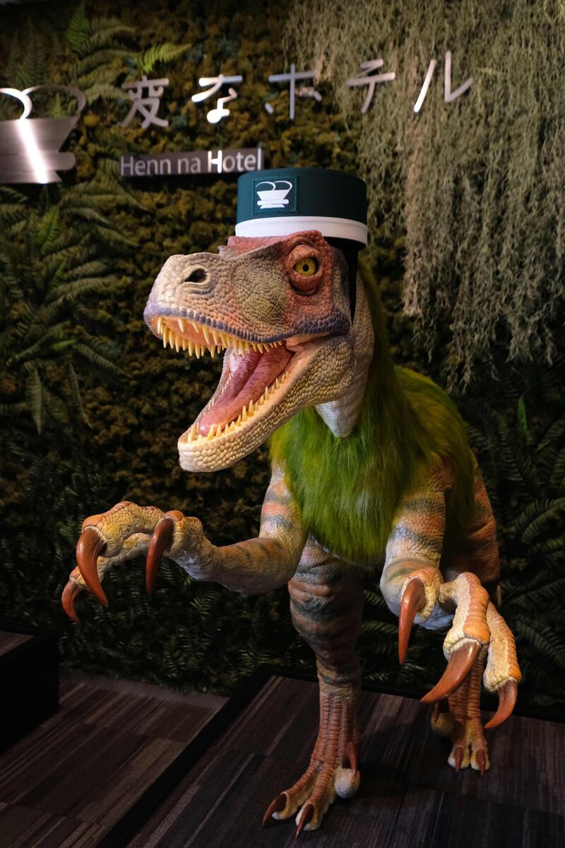 A robot dinosaur wearing a bellboy hat welcomes guests from the front desk at the Henn-na Hotel in Urayasu, suburban Tokyo.  AFP