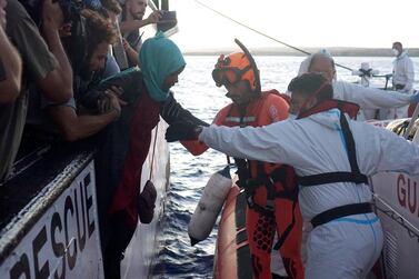 Migrants are evacuated by Italian Coast guard personnel from the Open Arms Spanish humanitarian boat off the coast of Lampedusa, southern Italy, on Thursday. AP