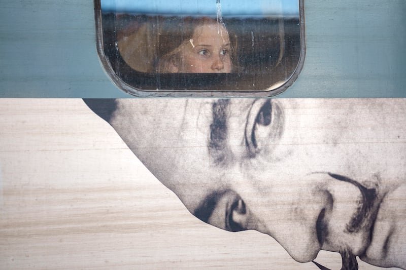 A child looks out from the window of a train displaying an advert for a Salvador Dali exhibition, at Gara de Nord in Bucharest, Romania. AP