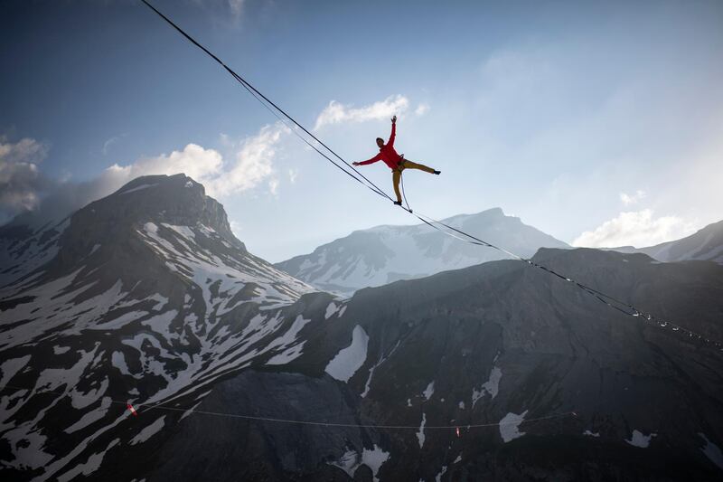 Lukas Irmler balances on a 800m long highline 200m above Segnesboden with view Piz Segnas, left, and Piz Dolf,  in Flims, Switzerland. The highline is Switzerland's longest and will be set up untill Sunday in the Sardona World Heritage Region.  AP