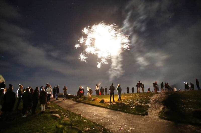 People on Calton Hill watch fireworks in Edinburgh. AP Photo