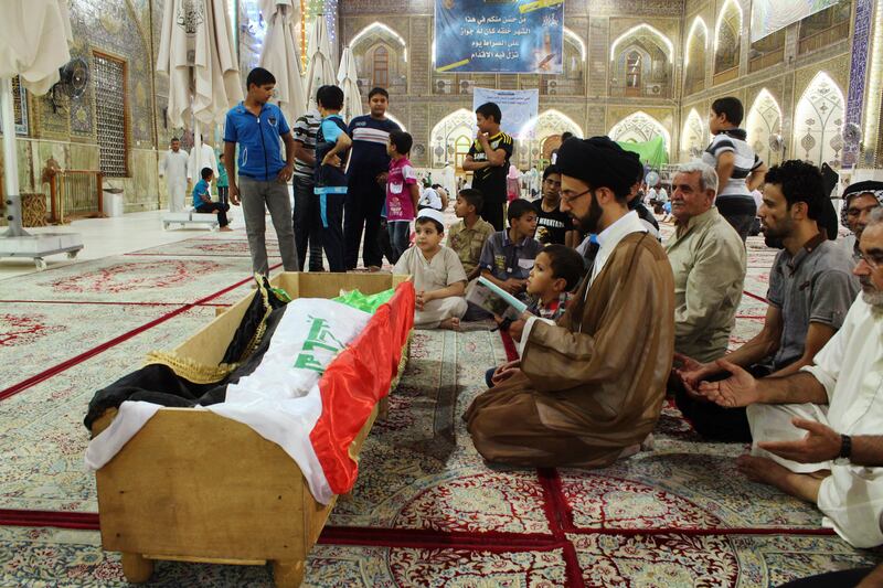 July 22, 2013: Mourners pray at the coffin of a victim killed during an attack on a prison in Taji, during a funeral at the Imam Ali shrine in Najaf. Reuters