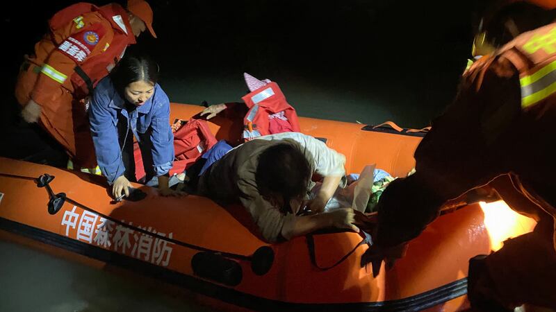 Rescuers move people by boat in Luding county, the epicentre of the quake. EPA