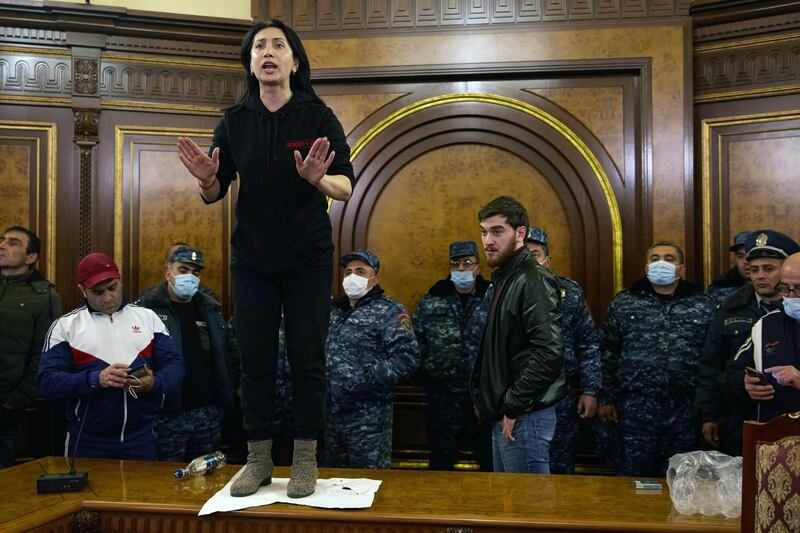 Police look on as a woman shouts among protestors who have stormed Armenian Prime Minister Nikol Pashinian's office after the announcement of a peace deal in the war between Armenia and Azerbaijan. Getty Images