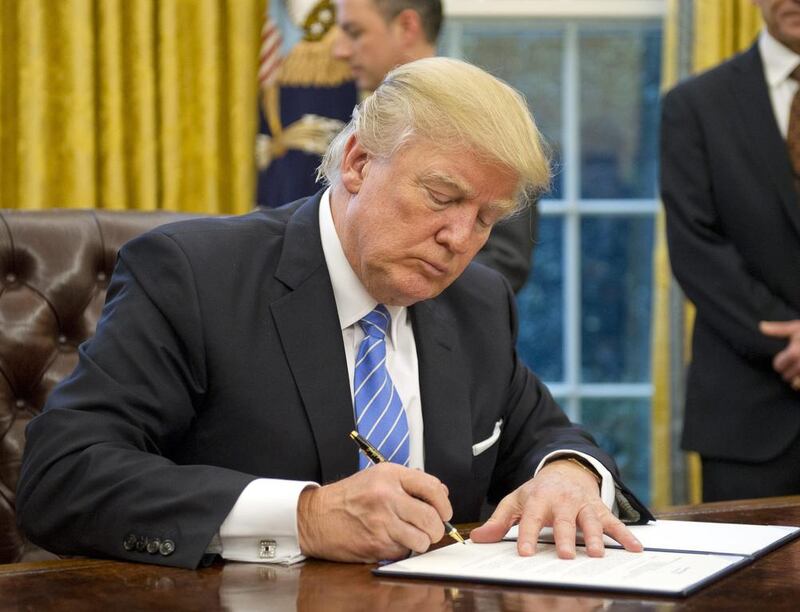 Donald Trump signs an executive order to withdraw from the Trans-Pacific Partnership agreement on his first Monday in the Oval Office. Ron Sachs via Bloomberg