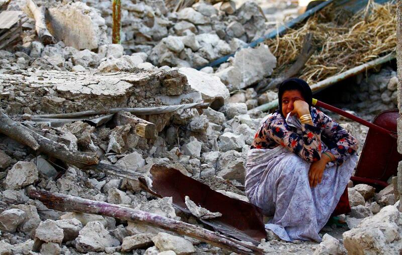 epa03655877 An Iranian woman sits on the rubble in the Shonbeh Twon in Bushehr province in southern Iran, 09 April 2013. The quakes, ranging in magnitude 6.3 on the Richter Scale, shook the Shanbeh town and other communities in Bushehr province in southern Iran on 09 April 2013. At least 37 people were killed in a 6.3-magnitude earthquake near Bushehr in southern Iran, state television reported.  EPA/MOHAMAD FATEMI *** Local Caption ***  03655877.jpg