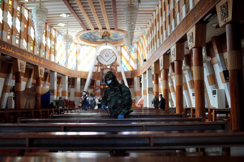 A member of the civil defense team disinfects inside Our Lady of Salvation church to prevent the spread of the coronavirus disease (COVID-19), in Baghdad, Iraq December 30, 2020. REUTERS/Thaier Al-Sudani