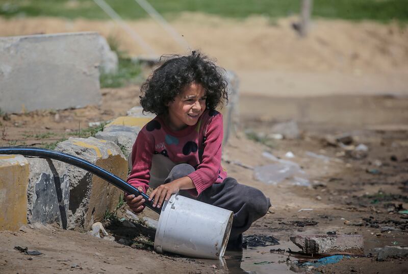 A Palestinian girl fills water for her family in Al Bureij refugee camp in central Gaza. EPA
