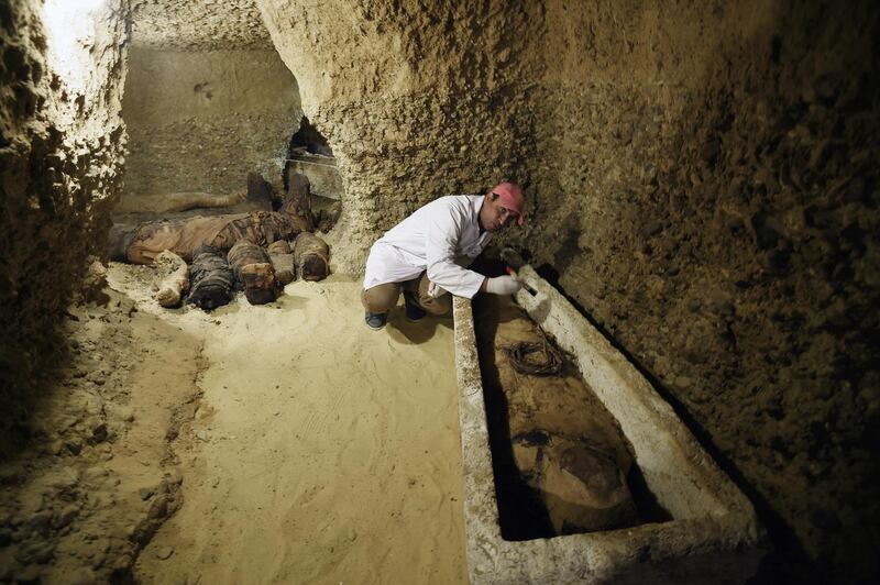 An archaeologist works on a mummy at Tuna el-Gebel, Egypt. EPA