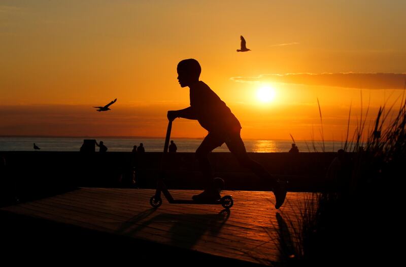 A boy plays with a scooter during the sunset at a skate park on the sea wall of Calais, France. Reuters