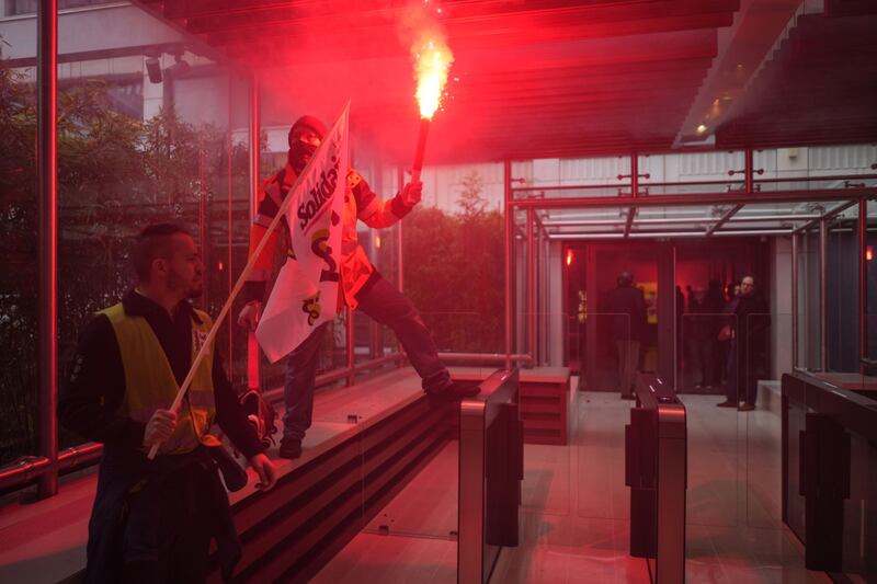 A protester holds a lit flare outside the LVMH headquarters during a demonstration. Bloomberg