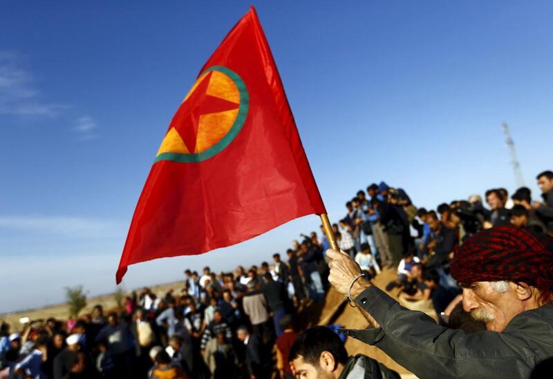 A Turkish Kurd holds a flag during the funeral of three Kurdish fighters killed during clashes in Kobane (REUTERS/Kai Pfaffenbach)