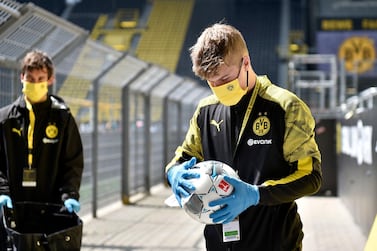 Ball boys disinfect the footballs before the German Bundesliga soccer match between Borussia Dortmund and Schalke 04 in Dortmund, Germany, Saturday, May 16. AP