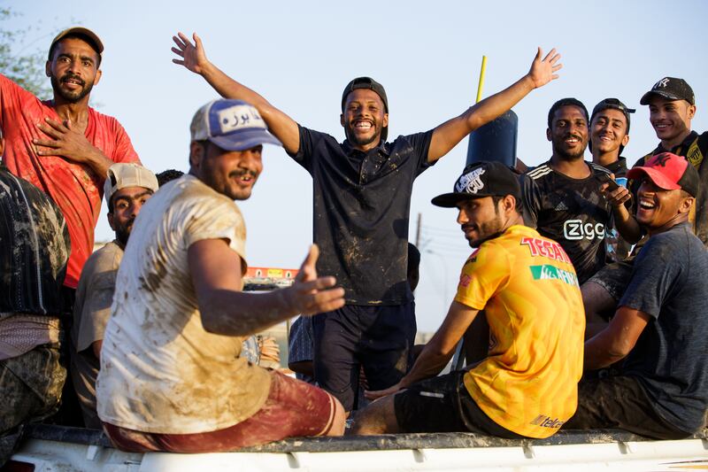 Volunteers helping to clean up the flooded town travel in a pick-up truck at the end of the day in Al Khaburah, Oman.