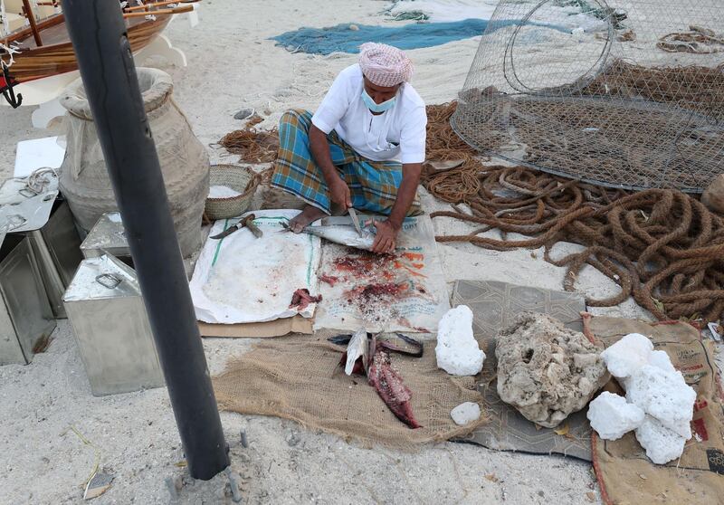 Sharjah, United Arab Emirates - Reporter: Razmig Bedirian. Arts. A fisherman prepares a fish for salting at the Heart of Sharjah for Sharjah Heritage Days. Monday, March 22nd, 2021. Sharjah. Chris Whiteoak / The National