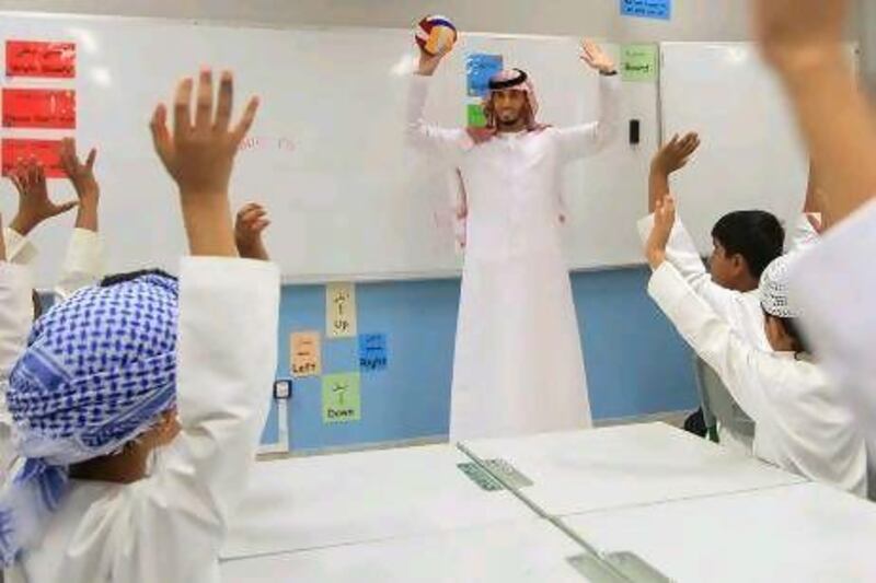 Ahmed Al Maamari, an Emirati teacher on his first day of school, interacts with third Grade students at Al Aasimah School in Abu Dhabi. Ravindranath K / The National