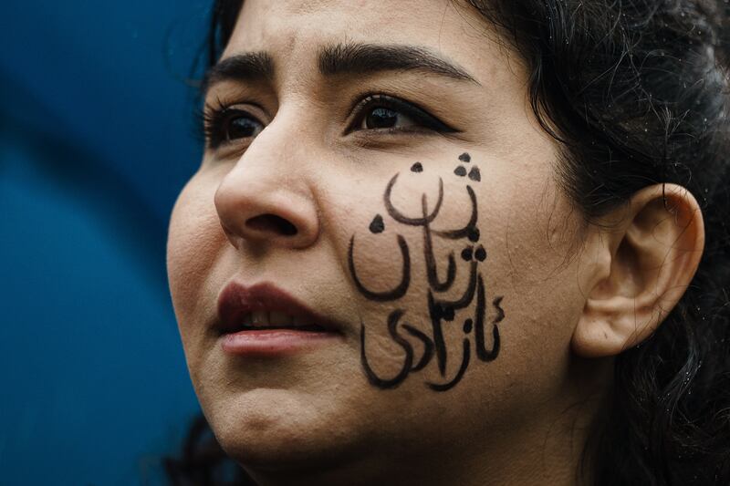 A Berlin protester's face paint reads 'woman, life, freedom'. EPA