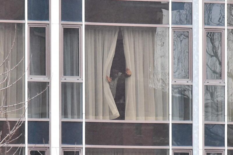 A man looks out of a window from inside the Radisson Blu hotel at Heathrow Airport. AFP