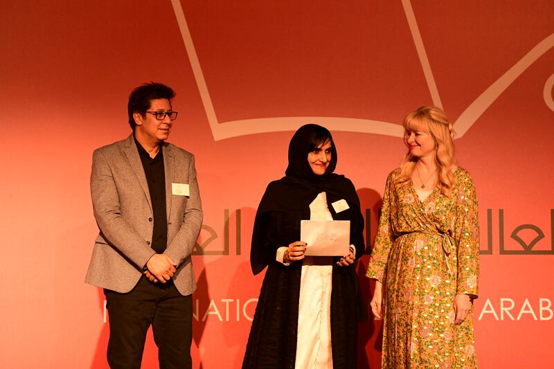 Reem Alkamali, the first Emirati author to be shortlisted for the prize, accepts her cheque.