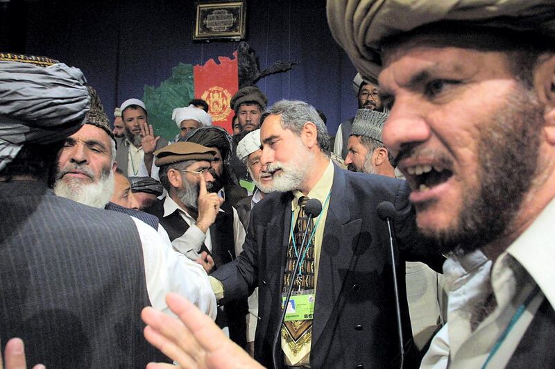 Afghan delegates discuss with each other the formation of a new legislative body during the Loya Jirga grand assembly in Kabul, 16 June 2002. Afghanistan's Loya Jirga traditional gathering was in uproar, as debate raged over the thorny issue of the make-up of the nation's assembly . AFP PHOTO-POOL/ Sergei GRITS (Photo by SERGEI GRITS / POOL / AFP)