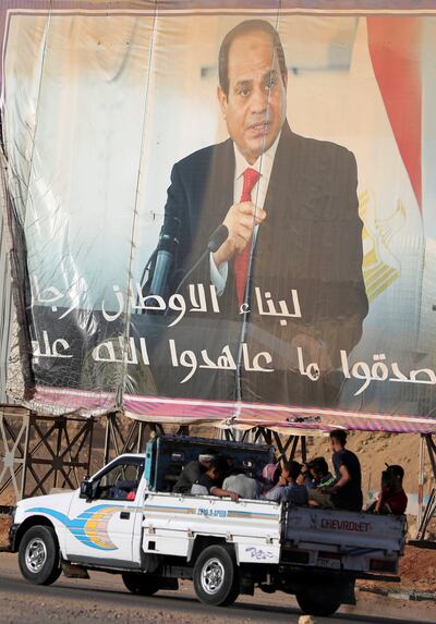 Workers drive past a banner of Egyptian President Abdel Fatah El Sisi who says he is considering ditching heavy subsidies on bread. Reuters