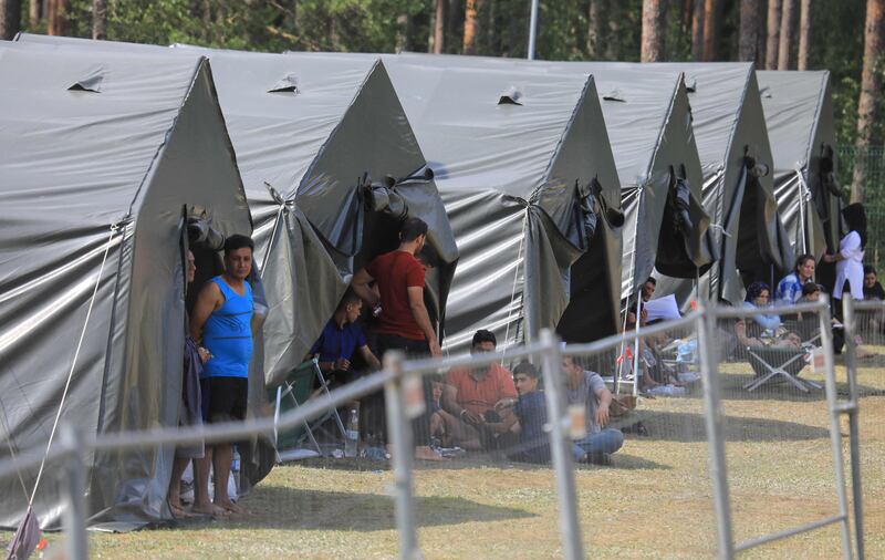 Migrants are seen outside tents at a camp near the border town of Kapciamiestis, Lithuania. AFP