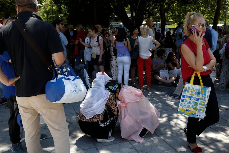Tourist hug each other in Syntagma square after a strong earthquake hit near the Greek capital of Athens, Friday, July 19, 2019. The Athens Institute of Geodynamics gave the earthquake a preliminary magnitude of 5.1 but the U.S. Geological Survey gave it a preliminary magnitude of 5.3. The Athens Institute says the quake struck at 2:38 p.m. local time (1113 GMT) about 26 kilometers (13.7 miles) north of Athens. (AP Photo/Petros Giannakouris)