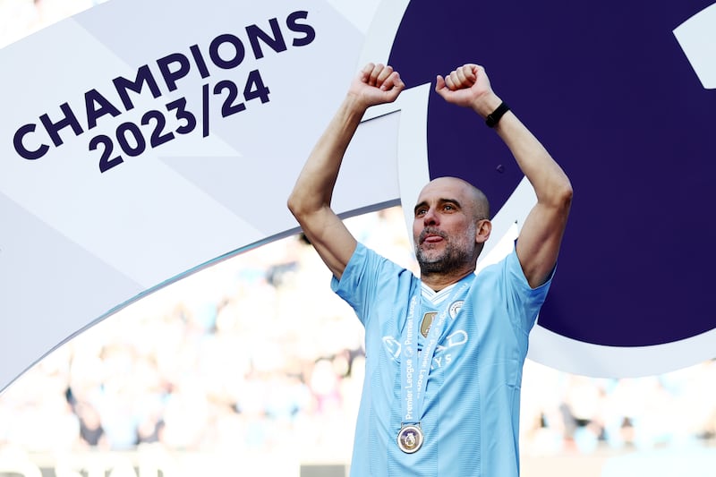 Manchester City manager Pep Guardiola celebrates with his Premier League winner's medal. Getty Images