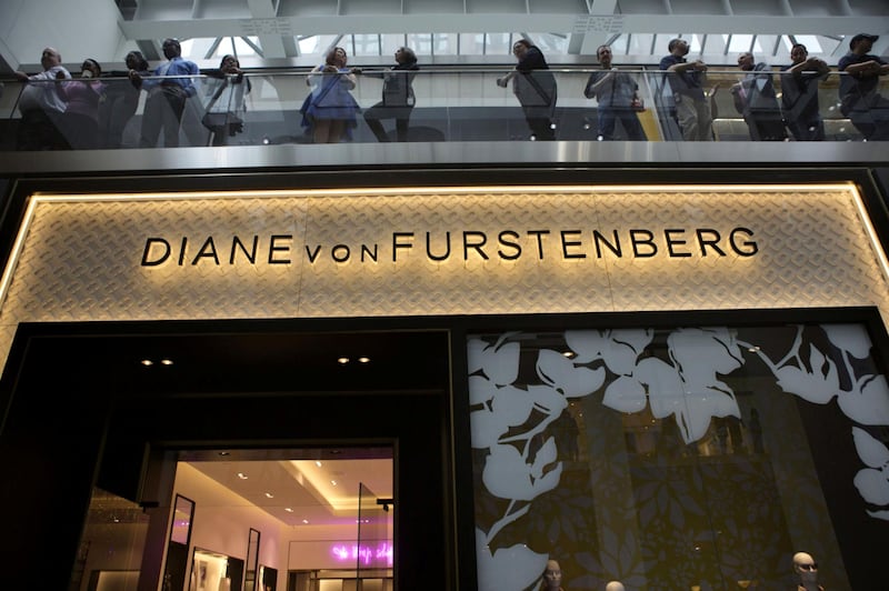 Attendees are seen standing above a Diane von Furstenberg Studio LP store during the grand opening of the Brookfield Place retail concourse in New York, U.S., on Thursday, March 26, 2015. Brookfield Place, located in the building complex formerly called the World Financial Center in the shadow of One World Trade Center, opened the doors to its glitzy new fashion stores and food marketplace this week. Photographer: Victor J. Blue/Bloomberg