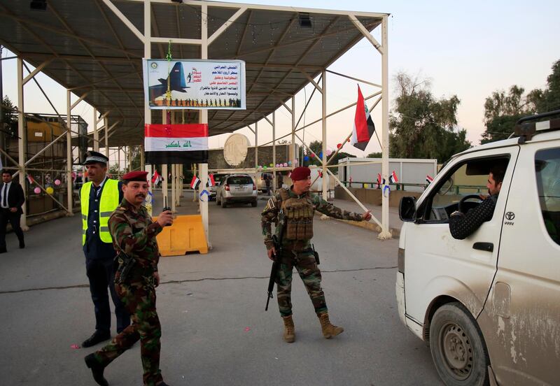 Iraqi security forces stand guard as they check motorists entering the Green Zone in Baghdad. AP Photo