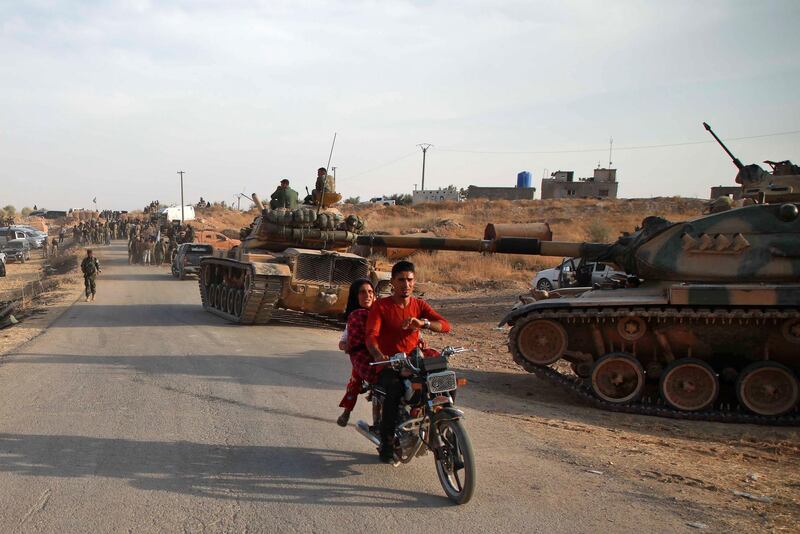 Syrian Arab civilians flee as Turkish troops with American-made M60 tanks and Turkish-backed Syrian fighters gather near the village of Qirata on the outskirts of the northern city of Manbij near the Turkish border.  Turkey wants to create a roughly 30-kilometre (20-mile) buffer zone along its border to keep Kurdish forces at bay and also to send back some of the 3.6 million Syrian refugees it hosts. AFP