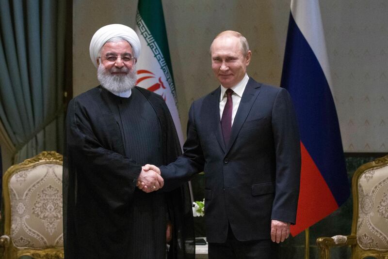 Iran's President Hassan Rouhani, left, and Russia's President Vladimir Putin shake hands before a meeting in Ankara, Turkey, Wednesday, April 4, 2018. The leaders of Russia, Iran and Turkey are meeting in the Turkish capital for talks on Syria's future. The leaders are expected to reaffirm their commitment to Syria's territorial integrity and the continuation of local cease-fires when they meet Wednesday. (Tolga Bozoglu/Pool Photo via AP)