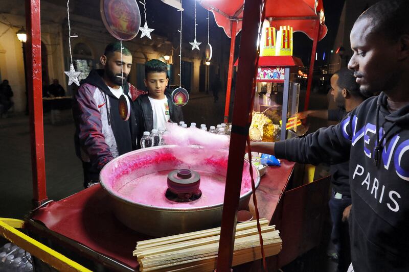 Visitors buy cotton candy at an entertainment area in Tripoli. AFP