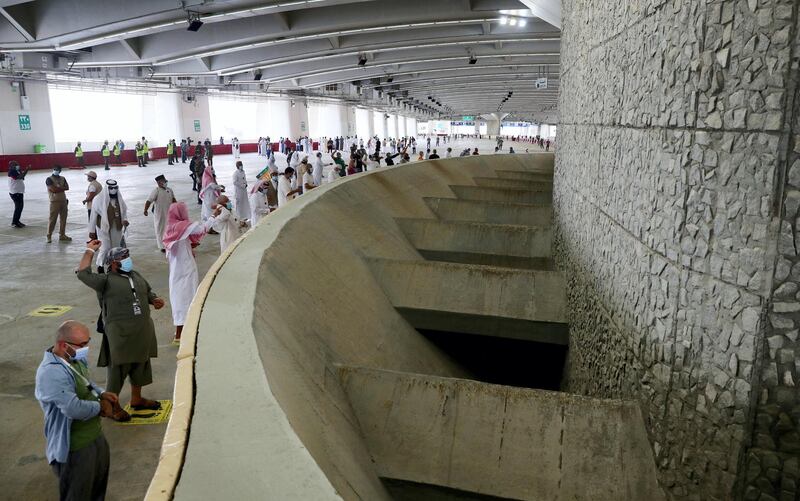 Muslim pilgrims, clad in face masks due to the coronavirus pandemic, throw pebbles as part of the symbolic al-A'qabah (stoning of the devil ritual) at the Jamarat Bridge during the Hajj pilgrimage in Mina, near Saudi Arabia's holy city of Mecca, on August 1, 2020. - Massive crowds in previous years triggered deadly stampedes during the ritual, but this year only up to 10,000 Muslims are taking part after millions of international pilgrims were barred because of the covid-19 pandemic crisis. (Photo by - / AFP)