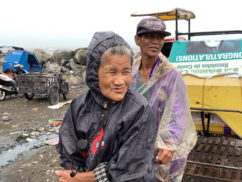 Filipinos stand near the coast during strong winds brought by Typhoon Kammuri, in Cavite City.  EPA