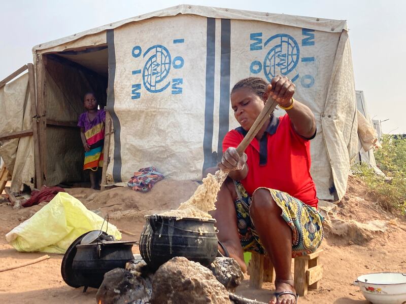 A woman cooks food at a camp for internally displaced people in Nigeria, where at least 13 million are going hungry. AP