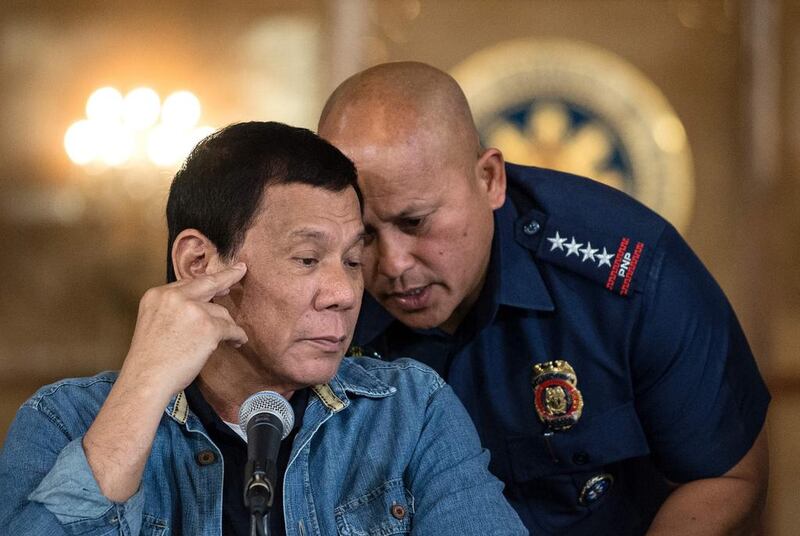 Philippine president Rodrigo Duterte, left, talks to Philippine National Police director general Ronald Dela Rosa during a press conference at the Malacanang palace in Manila on January 30, 2017.  The president has extended his deadly drug war until the last day of his term in 2022, but conceded the police force acting as his frontline troops was "corrupt to the core". Noel Celis/AFP