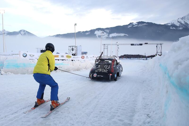 A skijoring compeitior is pulled along by a Porsche during the GP Ice Race  in Zell am See, Austria, on Saturday, February 01. Getty