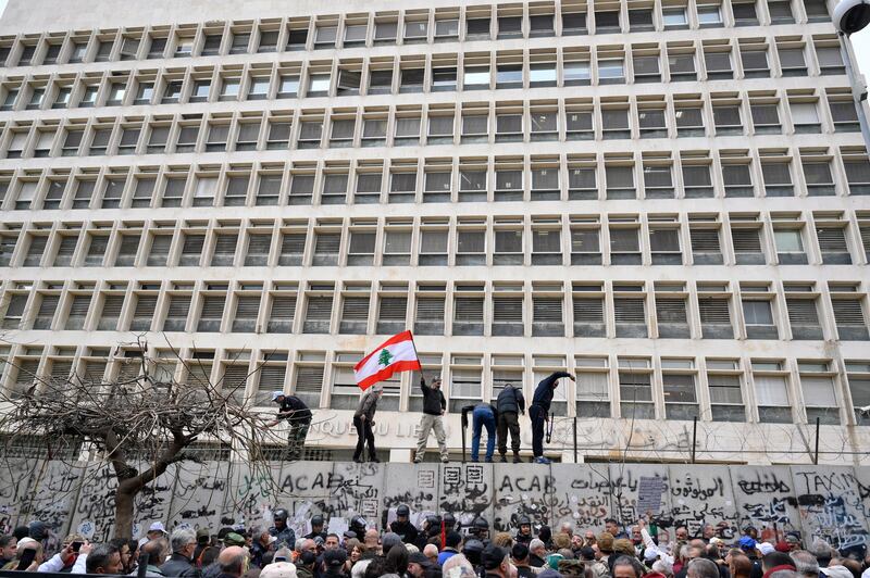 Retired members of the Lebanese security remove barbed wire barricade during a protest outside Central Bank in Beirut. EPA
