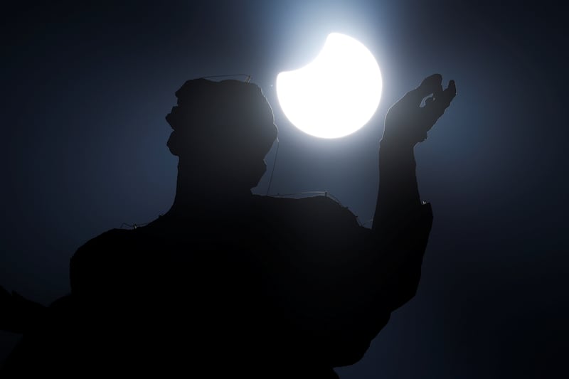 A statue on top of the Bernini's colonnade is pictured during a partial solar eclipse in St Peter's Square at the Vatican. Reuters