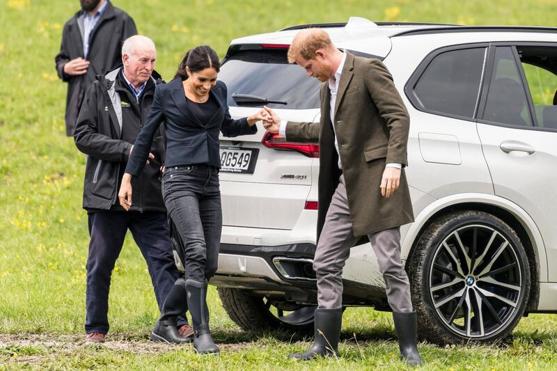 Prince Harry helps Meghan as they arrive to unveil a plaque dedicating 20 hectares of native bush to the Queen's Commonwealth Canopy project at The North Shore Riding Club. AFP